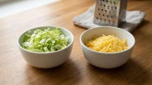 Étape 4: Émincez la salade en lanières et râpez le chedd...