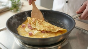 Étape 9: À l'aide de la spatule, repliez l'omelette en deu...